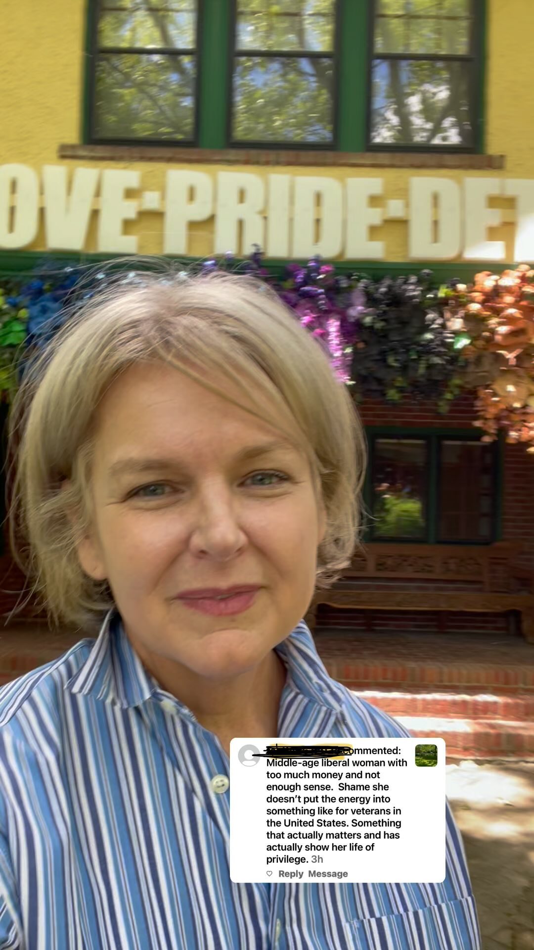 Kris in front of the Love Pride Detroit display on Burns Ave